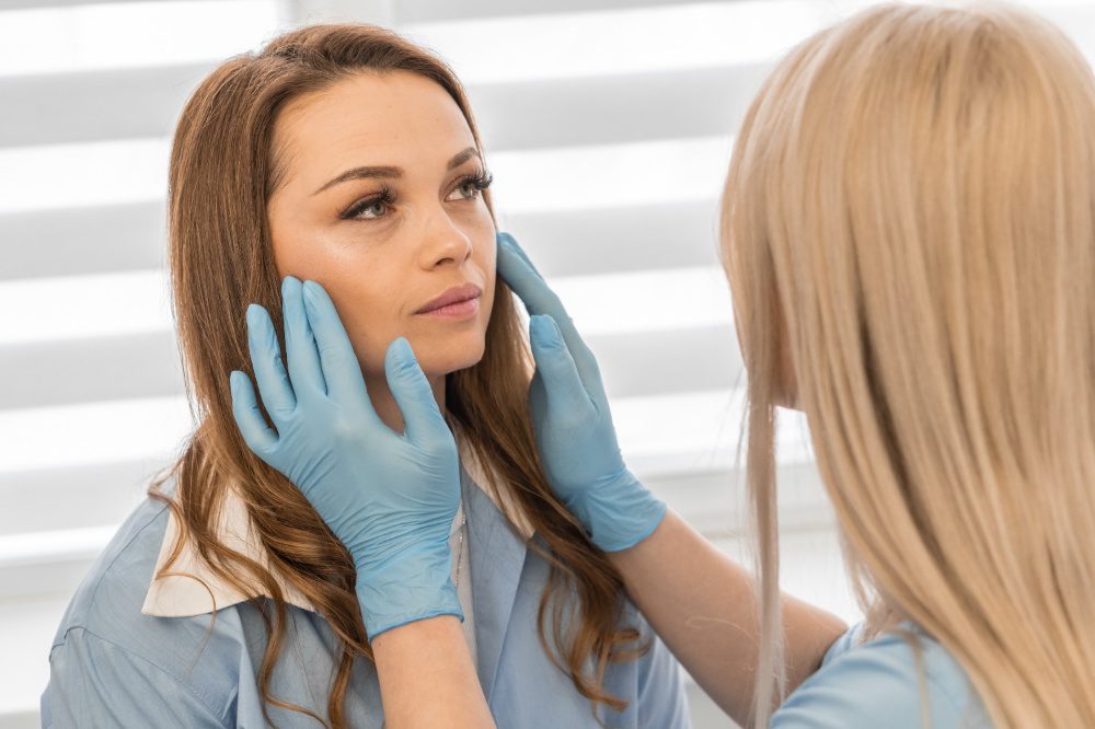Skincare specialist examining marionette lines on a woman’s face during a consultation.